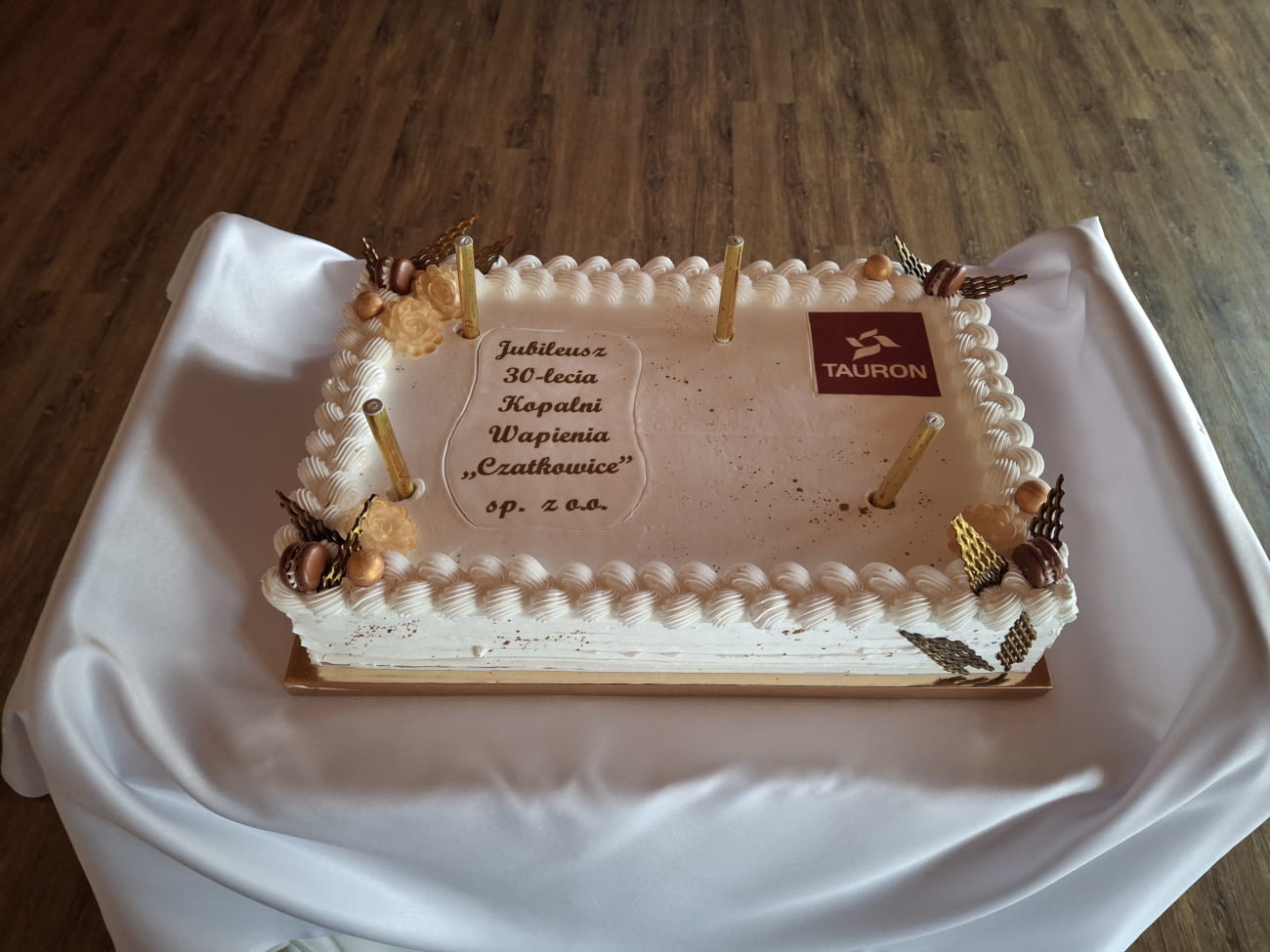 Tort z napisem - Jubileusz 30-lecia Kopalni Wapienia "Czatkowice" sp. z o.o. W rogu tortu logo TAURON