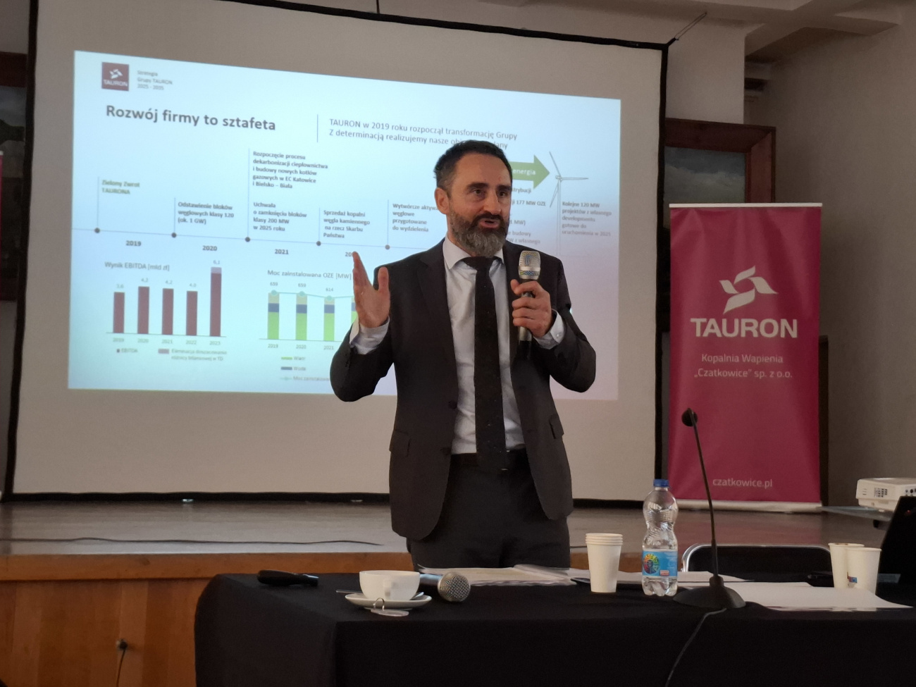 Wiceprezes Tauron Polska Energia prezentuje nową strategię Grupy TAURON na lata 2025-2035. W tle wyświetlana jest prezentacja
