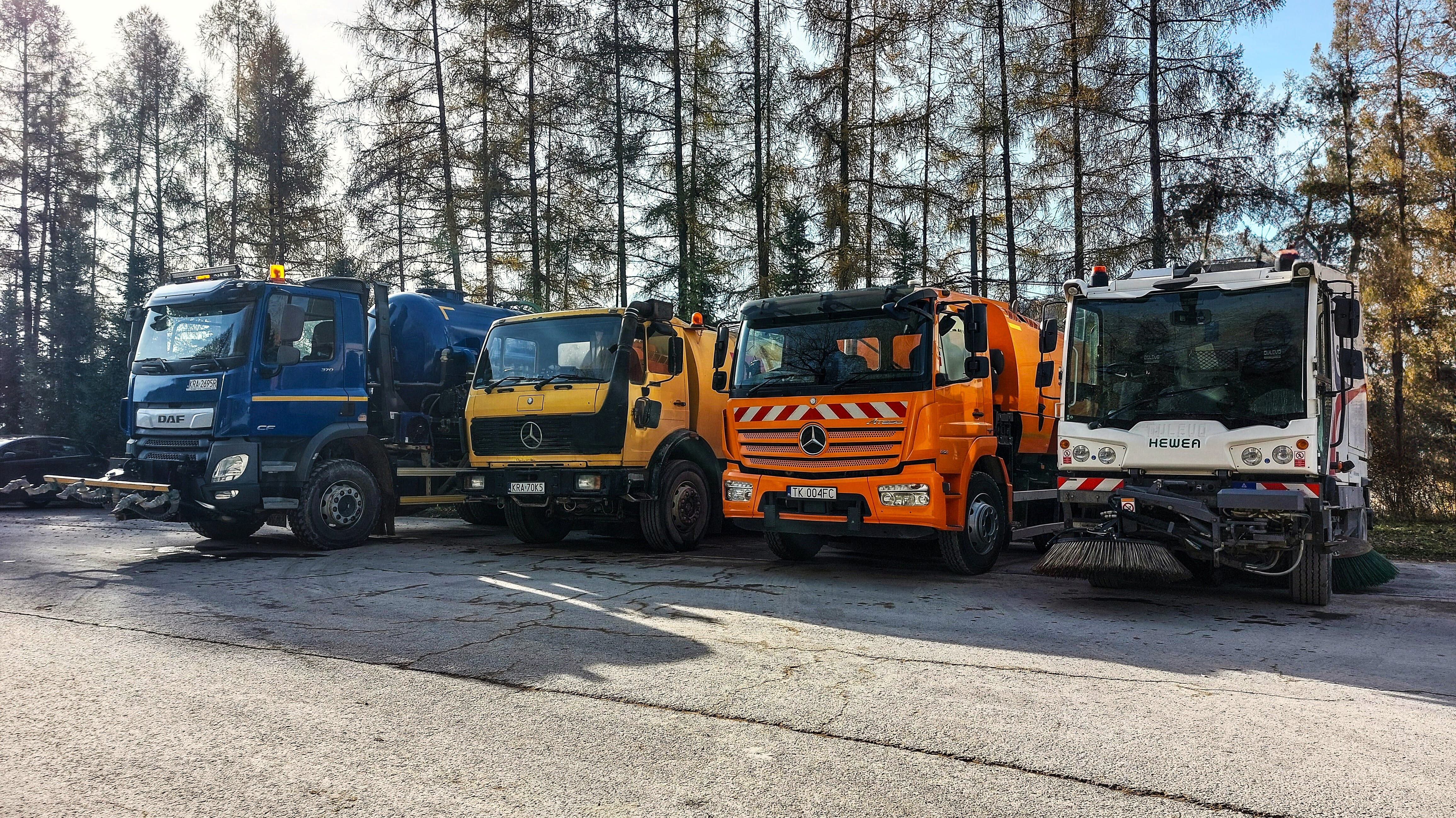 Cztery pojazdy przeznaczone do utrzymania czystości, zaprezentowane w rzędzie na terenie Kopalni